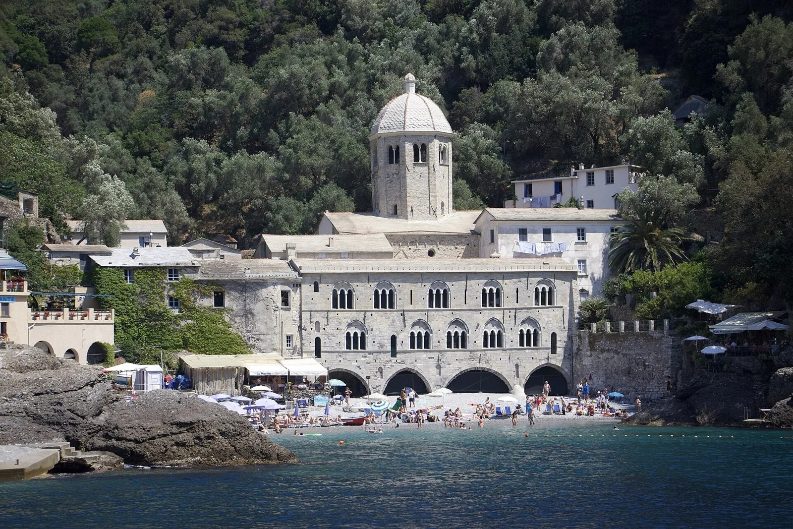 L'abbazia di San Fruttuoso con la cupola ottagonale affacciata sulla piccola spiaggia, circondata dal bosco del promontorio di Portofino